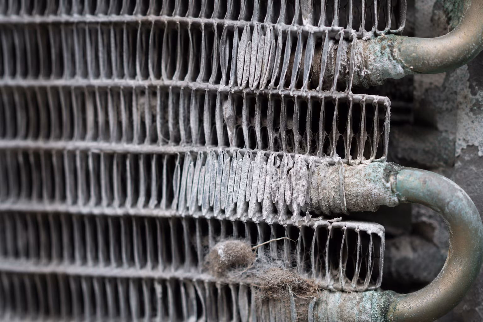 Close-up of aluminum condenser coil fins pitted by salt-air corrosion in Florida